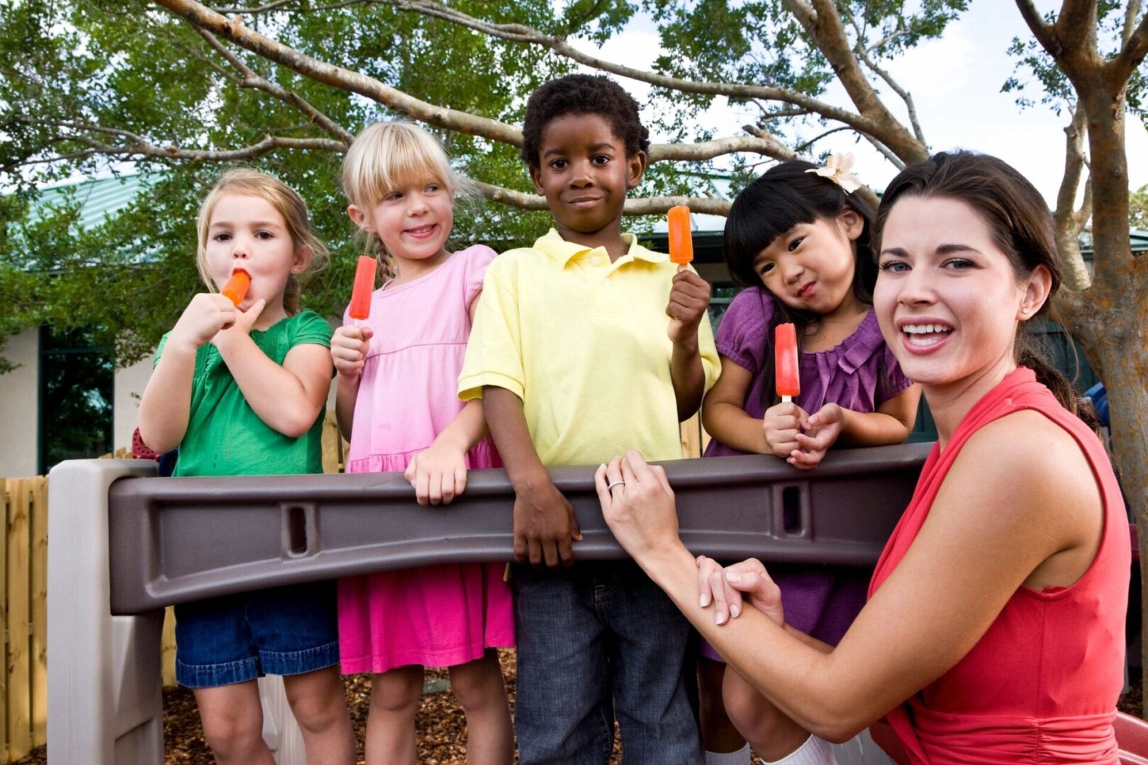 fm=f_7736 Children enjoy popsicles on a playground.